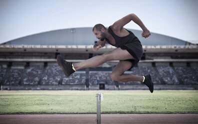 Athlete jumping over hurdle - ZEF007477