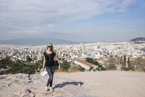 Griechenland, Athen, Blick von der Akropolis auf die Stadt mit einer Touristin im Vordergrund - CHPF000048