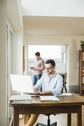 Junger Mann arbeitet zu Hause am Computer - UUF003326