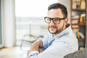 Porträt eines lächelnden jungen Mannes mit Brille - UUF003330