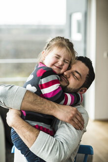 Father and daughter hugging at home - UUF003366