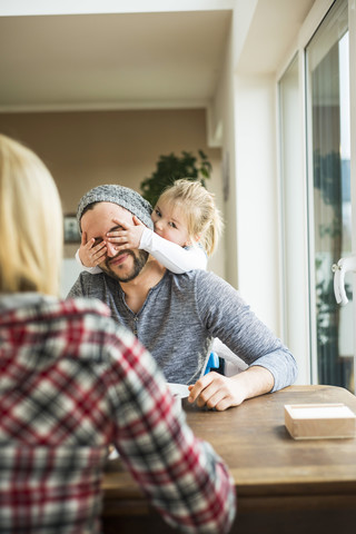 Tochter bedeckt die Augen des Vaters, lizenzfreies Stockfoto