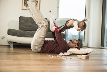 Happy father and daughter playing at home - UUF003404