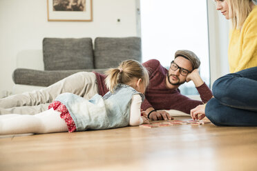 Familie spielt Spiel auf dem Boden - UUF003397