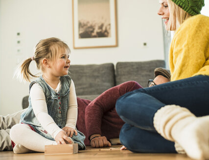 Familie spielt Spiel auf dem Boden - UUF003398