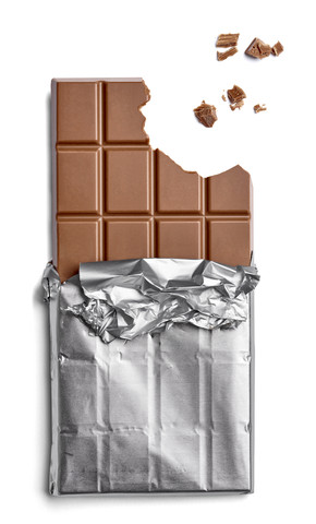Schokoladenriegel und Krümel auf weißem Hintergrund, lizenzfreies Stockfoto