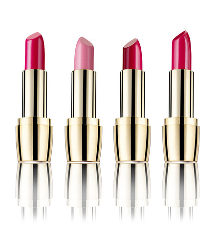 Row of four lipsticks in front of white background stock photo