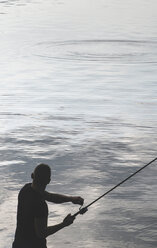Silhouette of man fishing at dam - DEGF000235