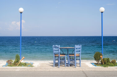 Griechenland, Tisch und Stühle einer Taverne am Meeresufer - DEGF000244