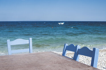 Griechenland, Tisch und drei Stühle am Meeresufer - DEGF000247