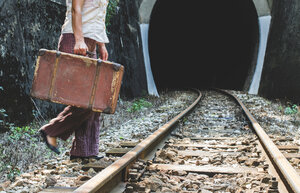 Bulgarien, Frau auf Eisenbahnstraße und Tunnel, Koffer in der Hand - DEGF000289