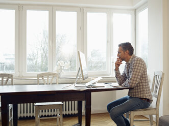 Germany, Cologne, Mature man working from home - RHF000477