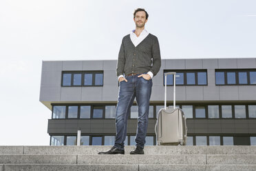 Businessman standing on stairs with his suitcase - PDF000770