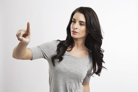 Portrait of young woman pointing in the air stock photo