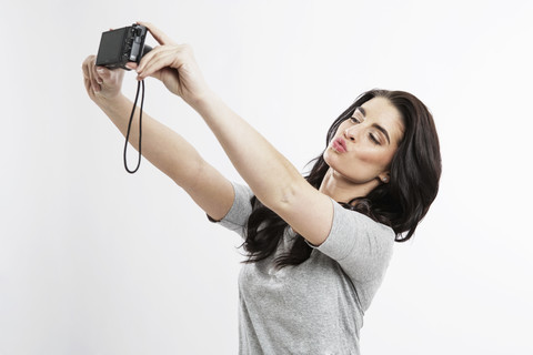 Porträt einer jungen Frau, die ein Selfie mit der Kamera macht, lizenzfreies Stockfoto