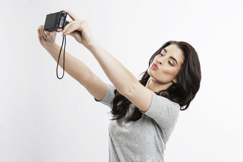 Porträt einer jungen Frau, die ein Selfie mit der Kamera macht - GDF000677