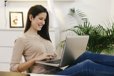 Junge Unternehmerin bei der Arbeit mit Laptop im Home Office - EBSF000446