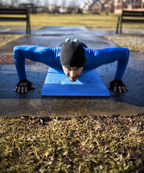 Spain, Gijon, athlete doing pushups in park - MGOF000123