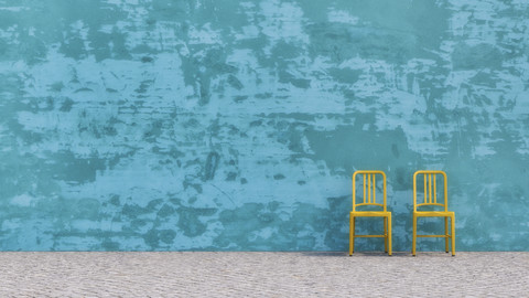 Two yellow chairs standing in front of blue concrete wall, 3D Rendering stock photo