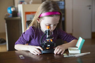 Kleines Mädchen mit Mikroskop zu Hause - SARF001355