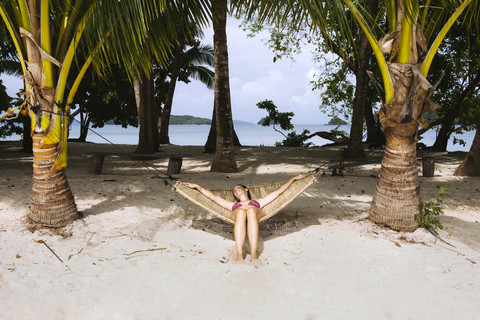 Philippinen, Palawan, Frau entspannt in Hängematte am Strand, lizenzfreies Stockfoto