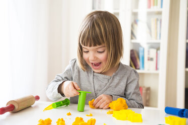 Little girl playing with yellow modeling clay - LVF002867