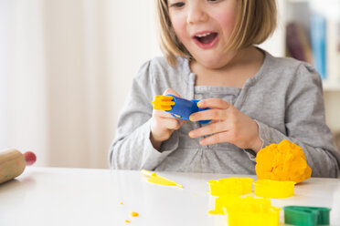 Little girl playing with yellow modeling clay - LVF002863