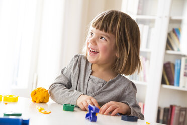Little girl playing with yellow modeling clay - LVF002859