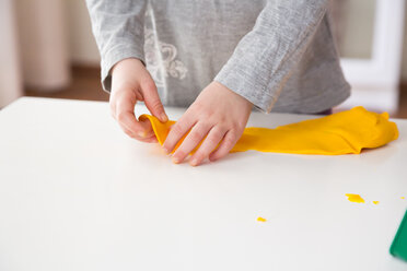 Little girl playing with yellow modeling clay - LVF002847