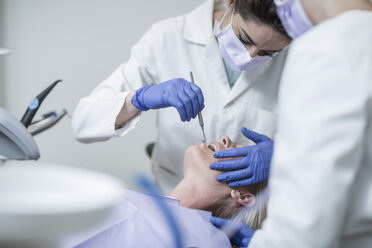 Female dentist examining patient with mouth mirror - ZEF003891