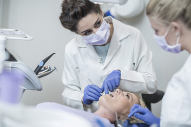 Female dentist examining patient with mouth mirror - ZEF003892