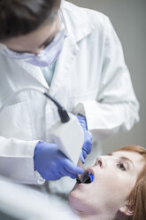 Zahnärztin bereitet Zahnaufhellung mit blauem Licht vor - ZEF003961