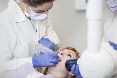 Zahnärztin untersucht die Zähne eines Patienten - ZEF003914