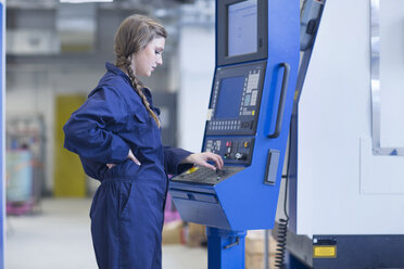 Techniker in einer Fabrikhalle bei der Arbeit an einer Fräsmaschine - SGF001329