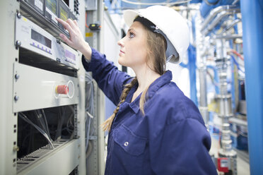 Technician in factory hall operating appliance - SGF001333