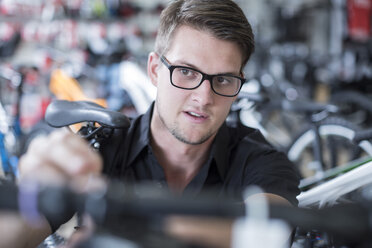 Young man working in bicycle shop - ZEF005410