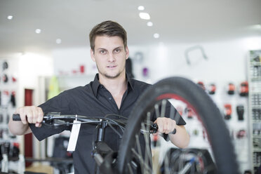 Young man working in bicycle shop - ZEF005023