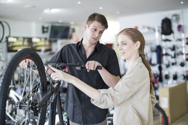 Young salesman and client looking at bicycles - ZEF005412