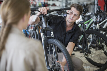 Young salesman and client looking at bicycles - ZEF005414