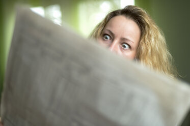 Horrified woman reading newspaper - FRF000199