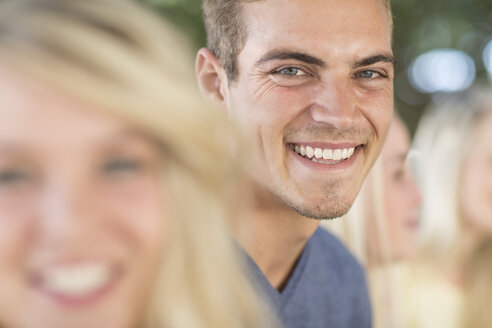 Lächelnder junger Mann unter Freunden im Freien - ZEF004616