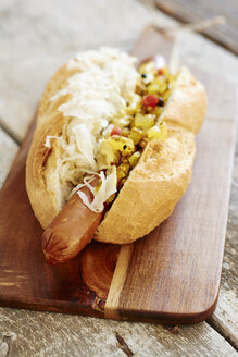 Veganer Hot Dog mit Sauerkraut und Relish auf Schneidebrett - HAWF000643