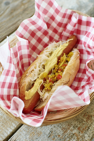 Veganer Hot Dog mit Sauerkraut und Relish auf Serviette im Korb, lizenzfreies Stockfoto