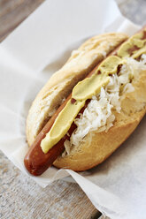 Veganer Hot Dog mit Sauerkraut und Senf auf Serviette - HAWF000646