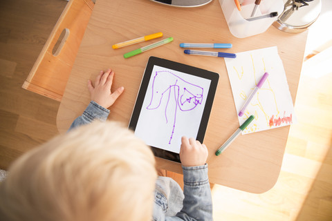 Little boy drawing with digital tablet stock photo