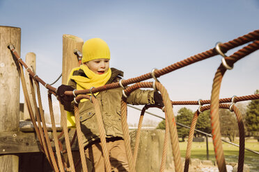 Kleiner Junge läuft auf einem Spielplatz über eine Hängebrücke - MFF001501