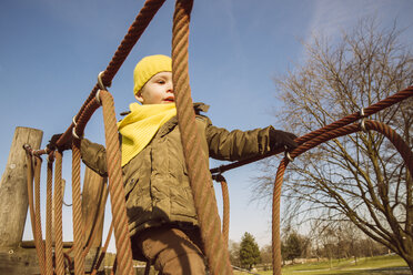 Kleiner Junge läuft auf einem Spielplatz über eine Hängebrücke - MFF001504