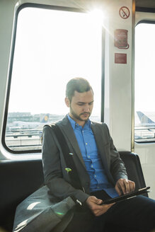 Deutschland, Frankfurt, junger Geschäftsmann im Bus am Flughafen - UUF003420