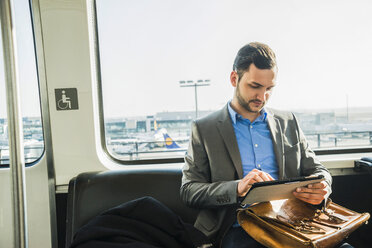 Germany, Frankfurt, young businessman in bus at the airport - UU003421