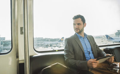 Germany, Frankfurt, young businessman in bus at the airport - UU003422